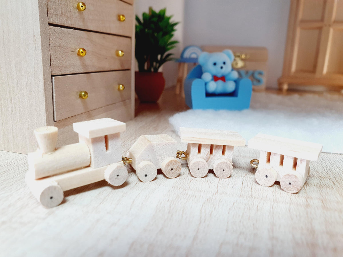 Wooden toy train shown at floor level, with its engine on the left and carriages extending across a miniature bedroom scene.