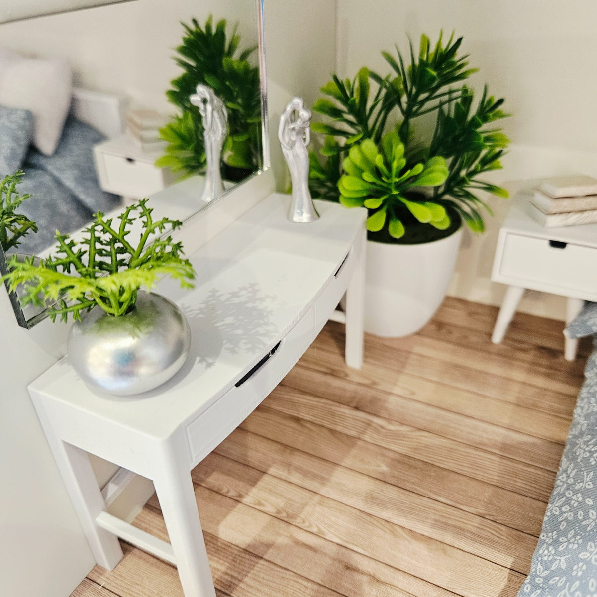 View from above of the white dressing table with closed drawers in a dolls house bedroom