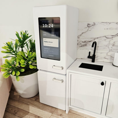Angled view of the white 1:12 scale dolls house fridge freezer beside a miniature sink