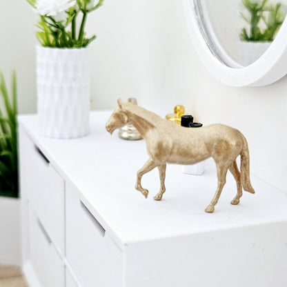 Gold colored cast resin horse on lounge sideboard,12th scale