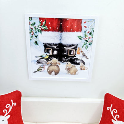 May include: A framed illustration of Santa's boots with a red and white trim. The boots are in the snow and surrounded by small animals, including bunnies and birds.
