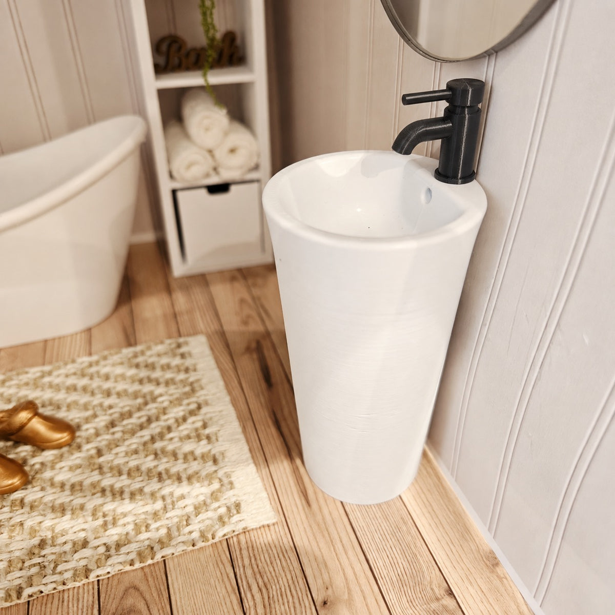 Angled view of white dolls house bathroom sink with black tap