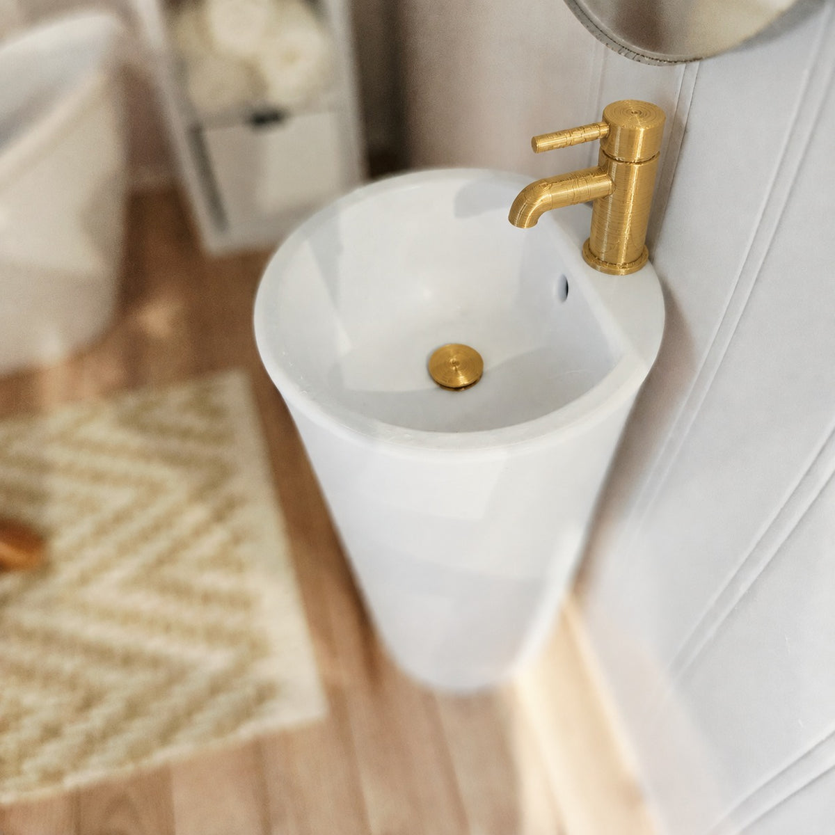 Close-up of white 1:12 scale bathroom sink with gold tap and matching plug