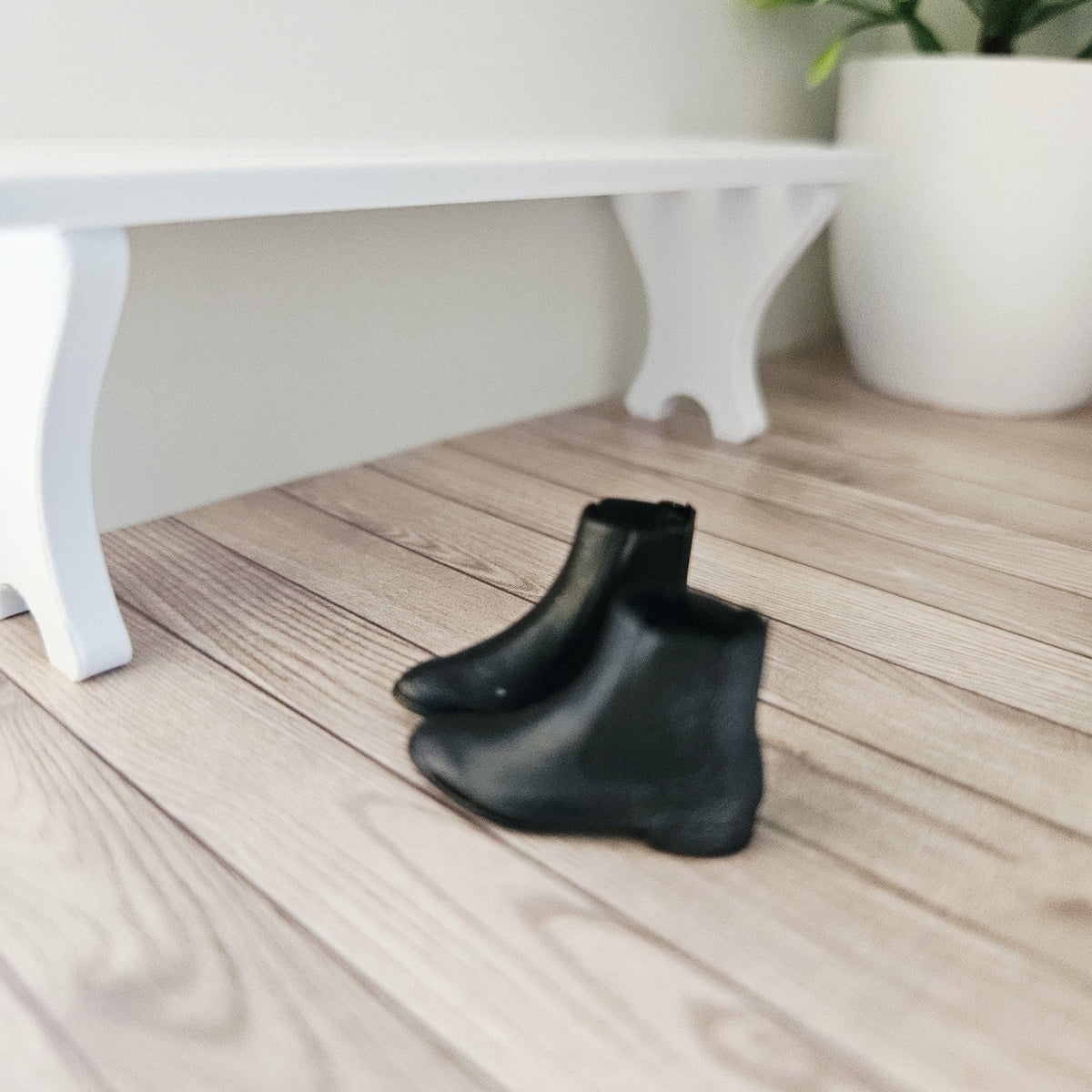 Black chelsea boots – one pair in a 1:12 scale dolls house display, detail view