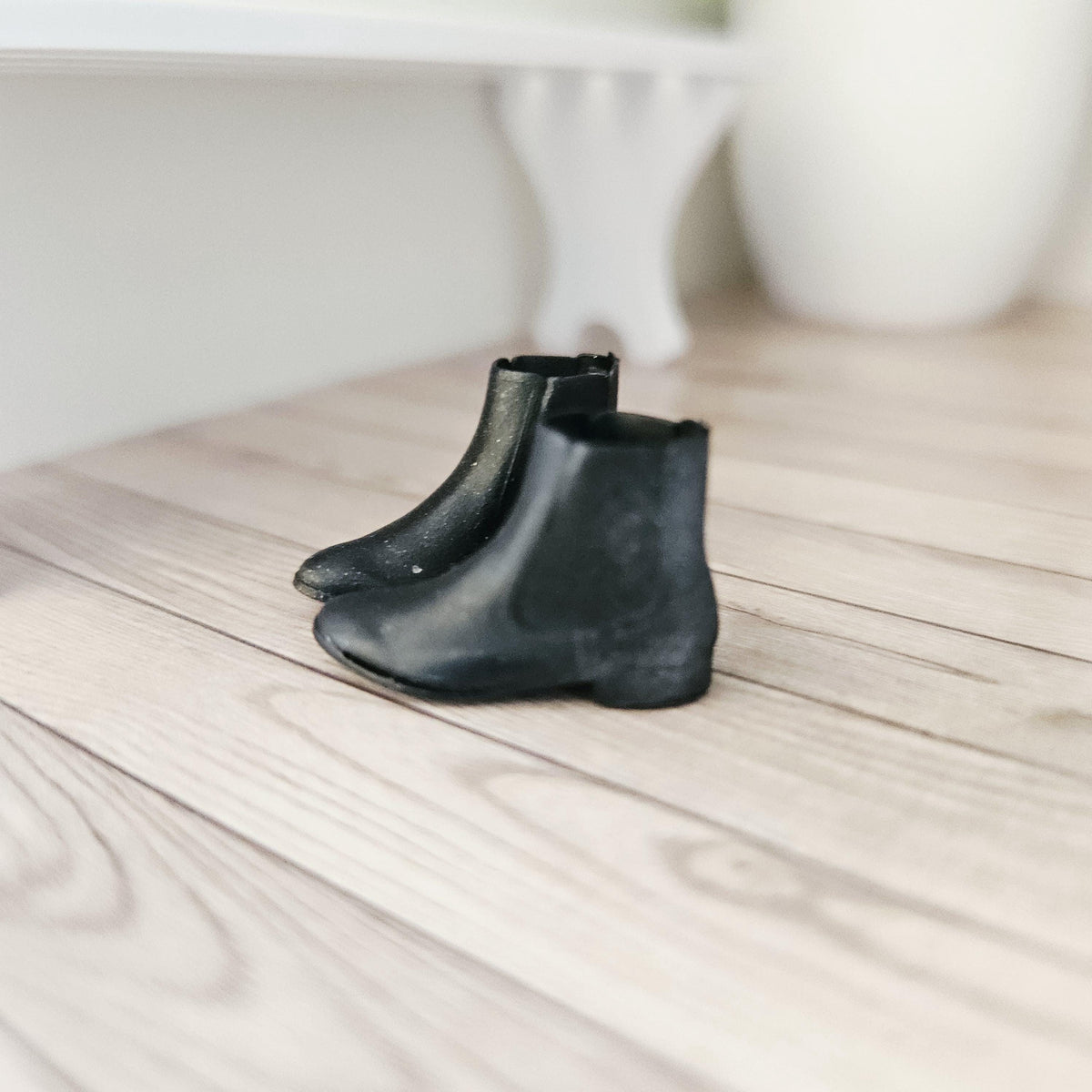 Black chelsea boots – one pair in a 1:12 scale dolls house display, detail view