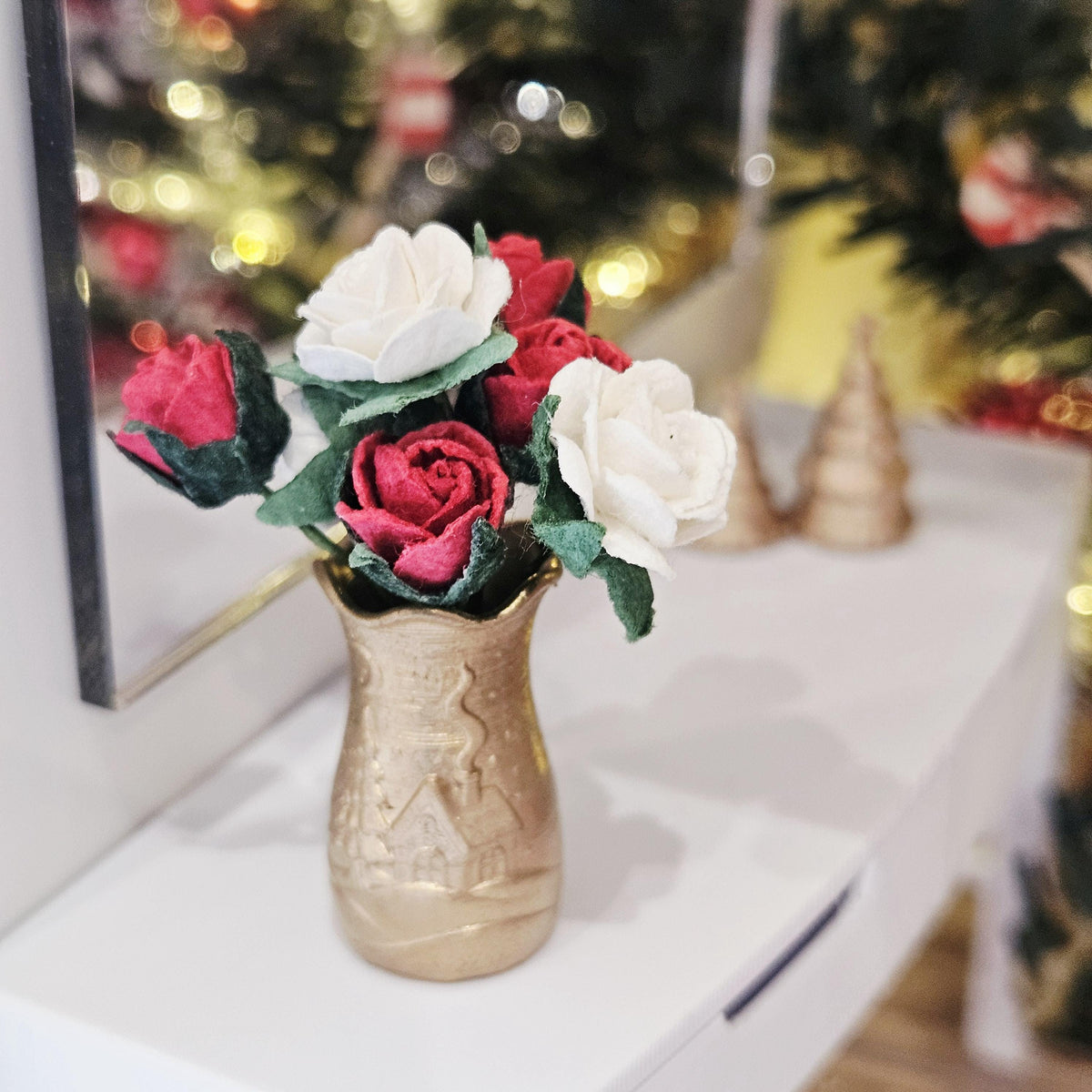 Gold Christmas scene vase with red and white roses on a dolls house sideboard, 1:12 scale