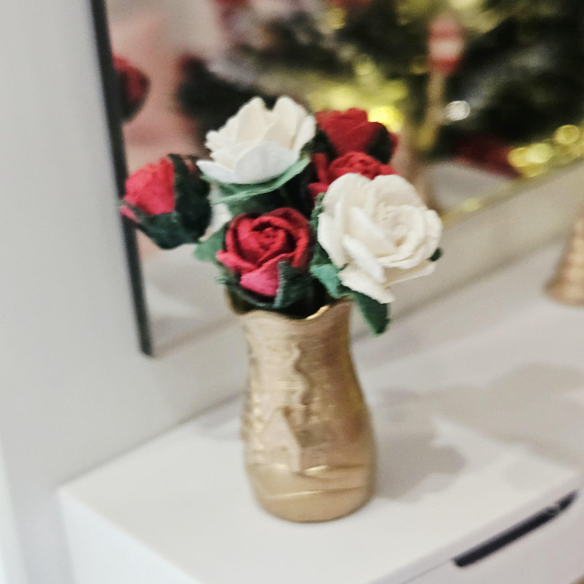 Gold Christmas scene vase with red and white roses on a dolls house sideboard, 1:12 scale