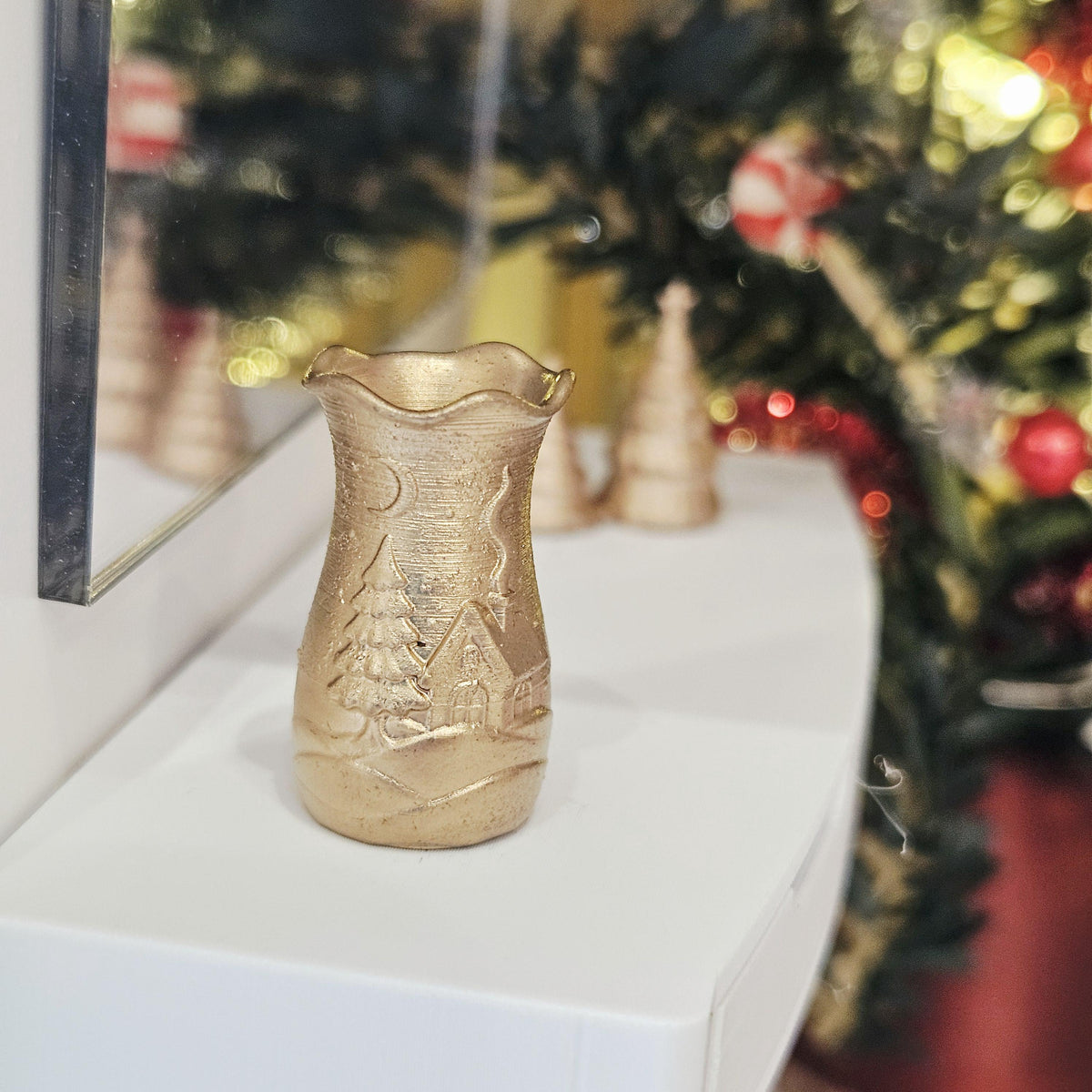 Gold flared christmas scene vase in a 1:12 scale dolls house display, detail view