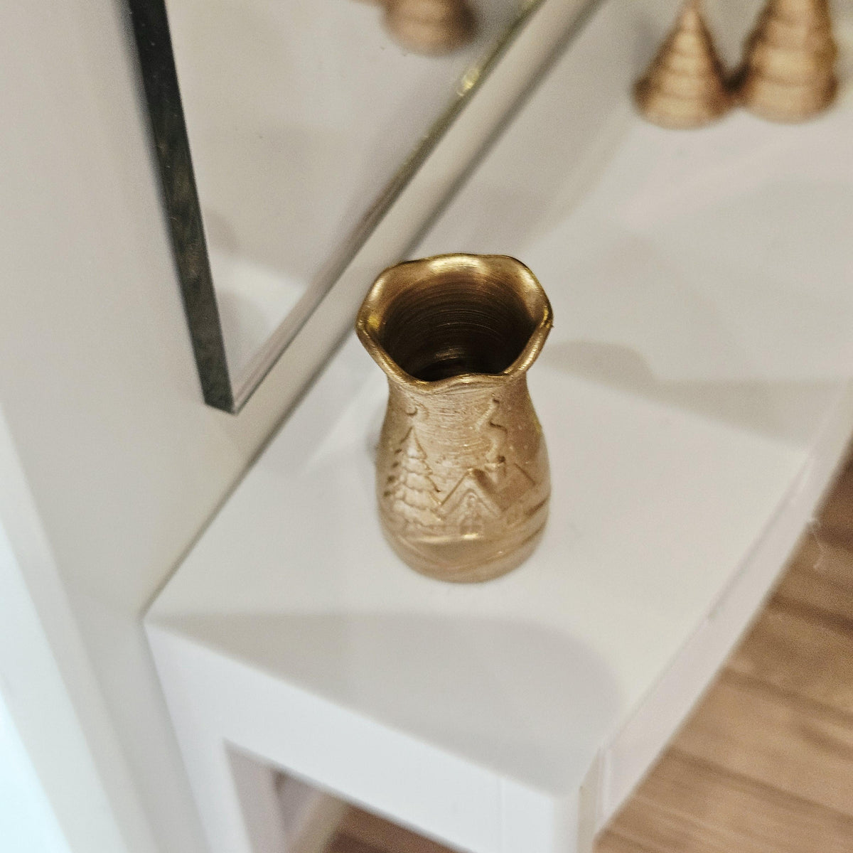 Gold flared christmas scene vase in a 1:12 scale dolls house display, detail view