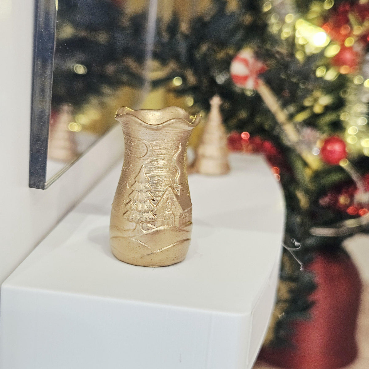 Gold flared christmas scene vase in a 1:12 scale dolls house display, detail view