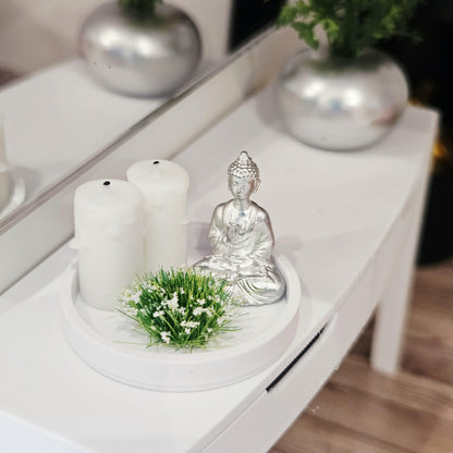 Silver Buddha ornament with two white candles and a white-flowering plant on a white tray, 1:12 scale dolls house