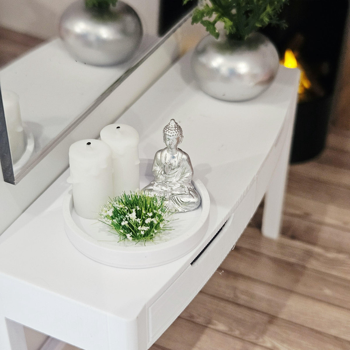 Silver Buddha ornament with two white candles and a white-flowering plant on a white tray, 1:12 scale dolls house