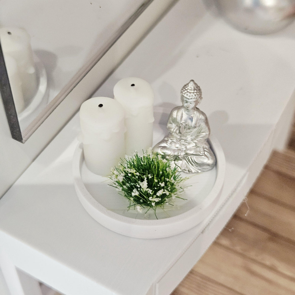 Silver Buddha ornament with two white candles and a white-flowering plant on a white tray, 1:12 scale dolls house