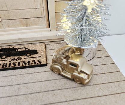 Gold pickup truck carrying a Christmas tree on a dolls house porch, 1:12 scale