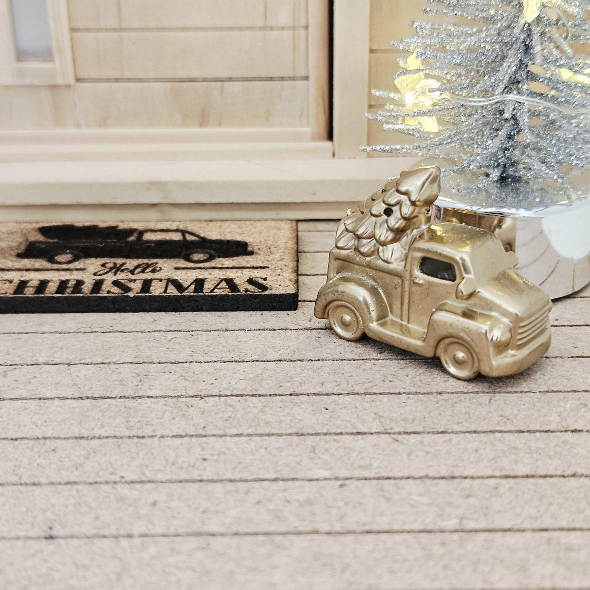 Gold pickup truck carrying a Christmas tree on a dolls house porch, 1:12 scale