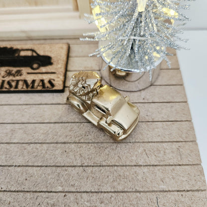 Gold pickup truck carrying a Christmas tree on a dolls house porch, 1:12 scale