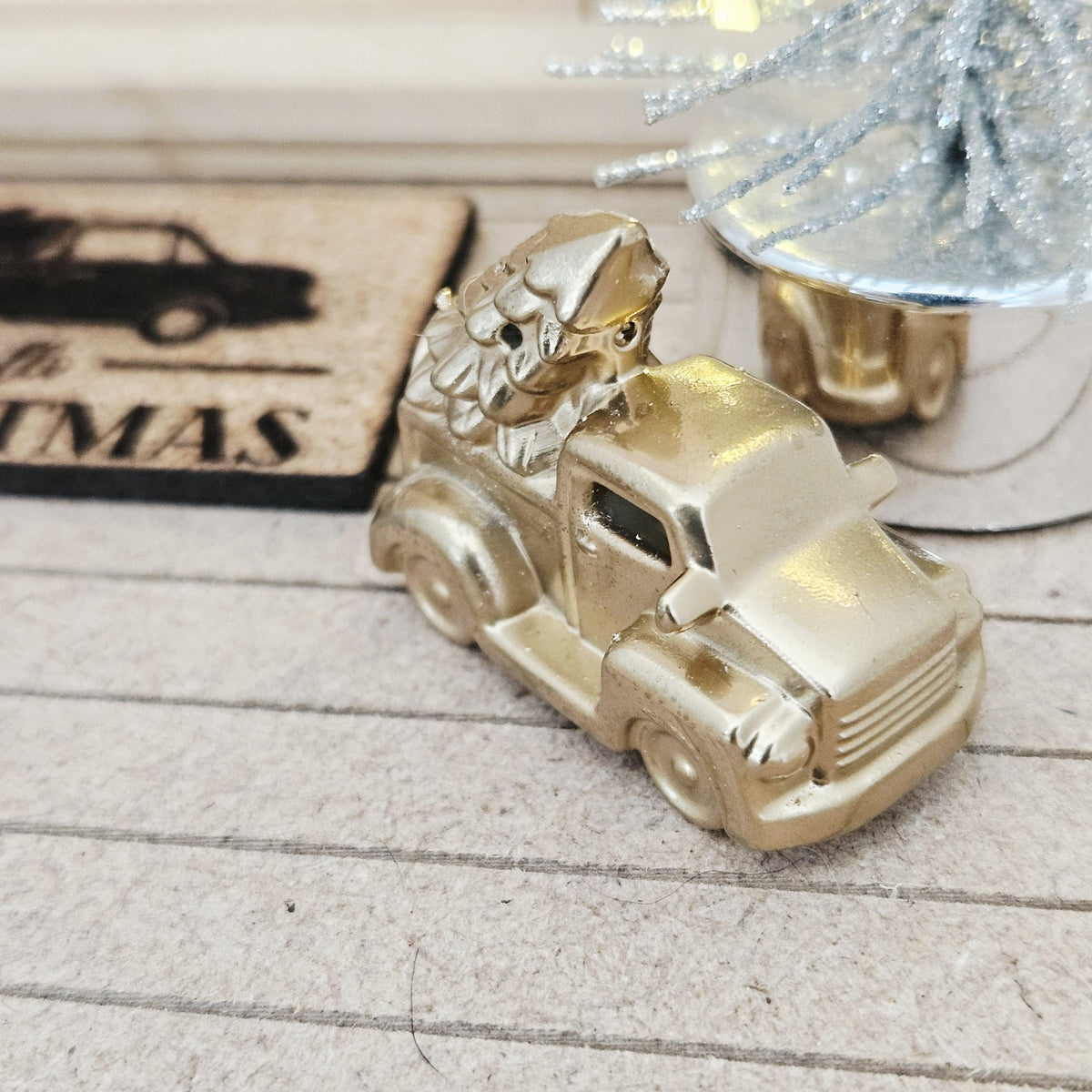 Gold pickup truck carrying a Christmas tree on a dolls house porch, 1:12 scale