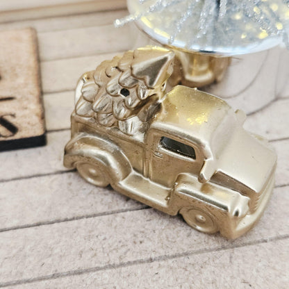Gold pickup truck carrying a Christmas tree on a dolls house porch, 1:12 scale