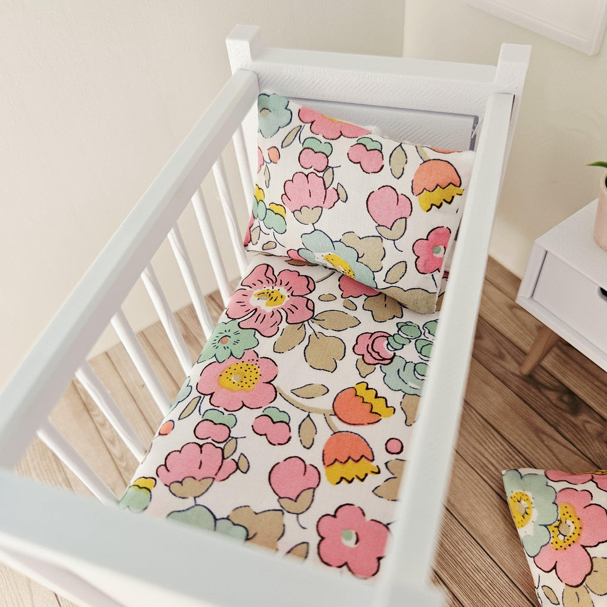pink & yellow liberty floral cot bedding set in a 1:12 scale dolls house display