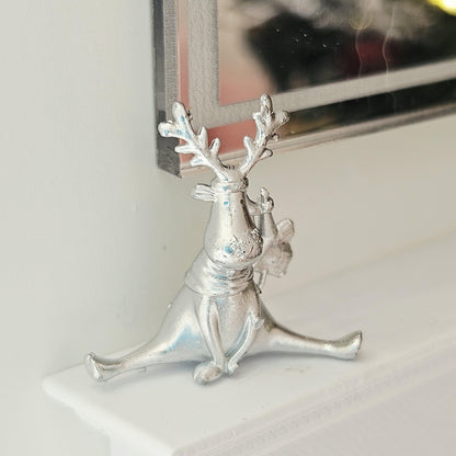 Silver seated christmas reindeer ornament in a 1:12 scale dolls house display