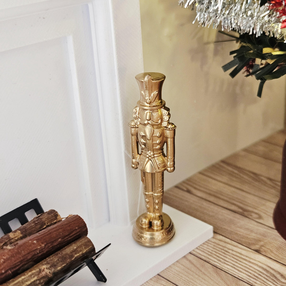 Gold christmas nutcracker ornament in a 1:12 scale dolls house display, detail view 2