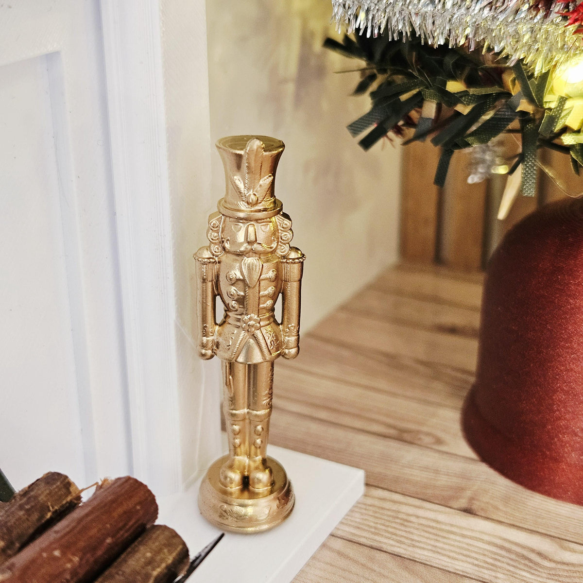 Gold christmas nutcracker ornament in a 1:12 scale dolls house display, detail view 3