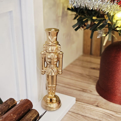 Gold christmas nutcracker ornament in a 1:12 scale dolls house display, detail view 3