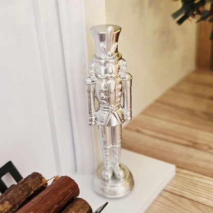 Silver christmas nutcracker ornament in a 1:12 scale dolls house display, detail view 6