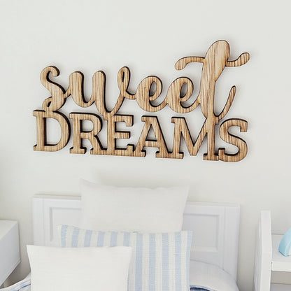 Front view of the Sweet Dreams sign, with flowing script above capital letters, displayed over a white miniature headboard.