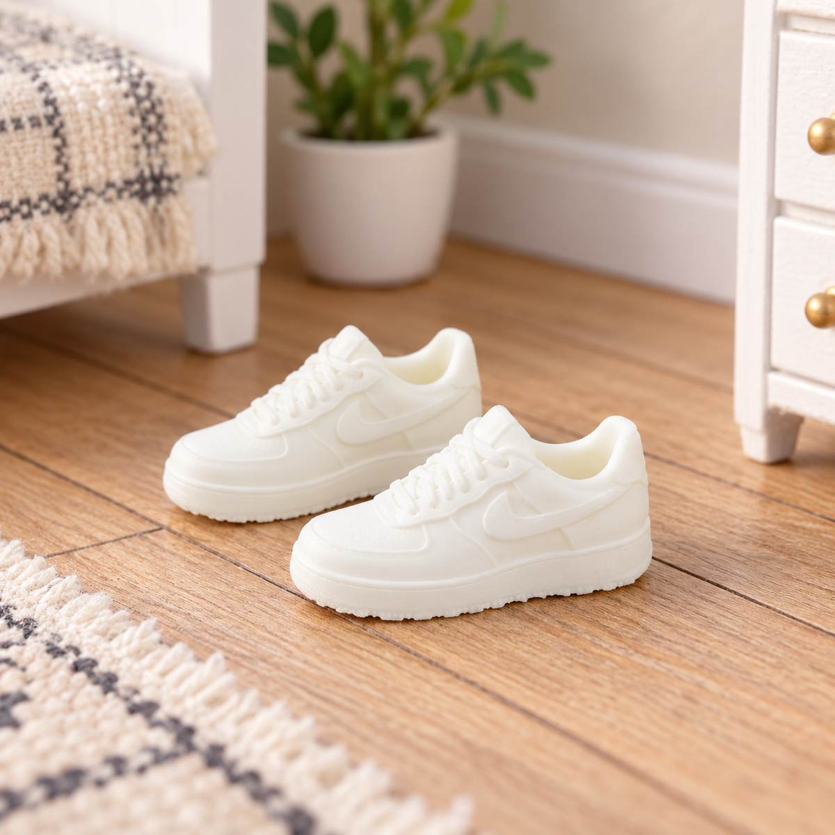 White 1:12 scale miniature trainers styled on a wooden dolls house bedroom floor