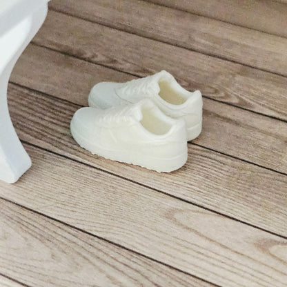 Actual white miniature trainers displayed in a 1:12 scale dolls house interior